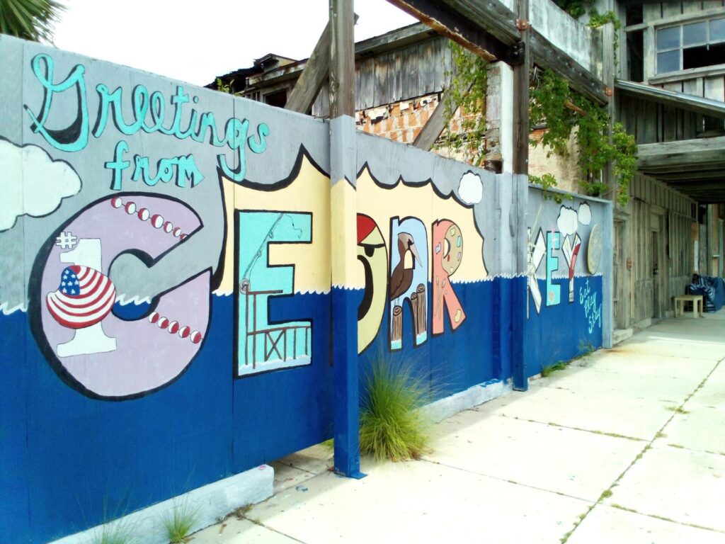 Image of a wall painted with Greetings from Cedar Key in graphic letters.